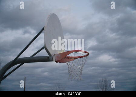 Eine rot-weiße Basketballkorb vor wolkigem Himmel. Stockfoto