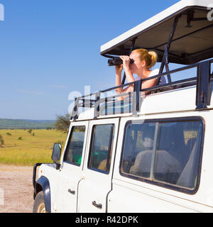 Frau auf Safari durch ein Fernglas schauen. Stockfoto