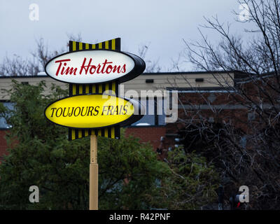 MONTREAL, KANADA - 3. NOVEMBER 2018: Tim Hortons Logo vor einem ihrer Restaurants in Quebec mit ihren sogan in französischer Sprache. Tim Hortons ist ein Cafe Stockfoto