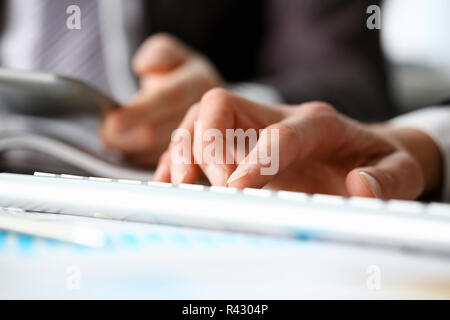 Männliche Waffen in Anzug Tippen auf Weiß Stockfoto