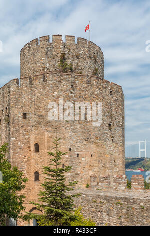 Blick auf ein Wehrturm in der Festung Rumeli, Istanbul, Türkei, mit der Fatih Brücke im Hintergrund. Stockfoto