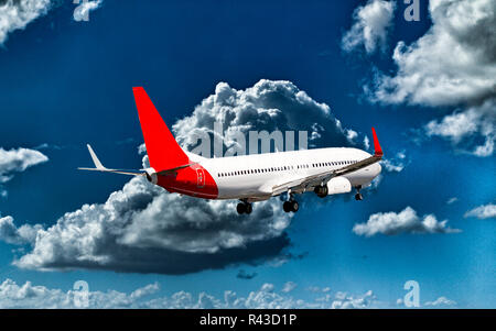 Ein Passagierflugzeugen flyng in einem pulsierenden blauen Himmel, mit gut entwickelten helle weiße Cumulonimbuswolken, Detailansicht. Stockfoto