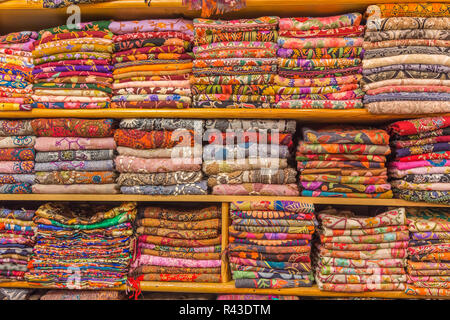 Bunte Schals angezeigt ordentlich auf Regalen, bereit für den Verkauf in einem Basar gefaltet. Stockfoto