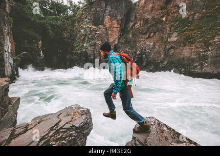 Aktiver Mann sprang auf den Felsen reisen Abenteuer aktiv Urlaub gesunden Lebensstil Extremsport über Canyon Fluss Stockfoto