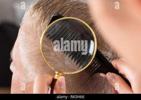 Arzt des Patienten Haare durch Lupe suchen Stockfoto