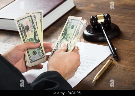Korrupte Richter zählen Geld am Schreibtisch Stockfoto