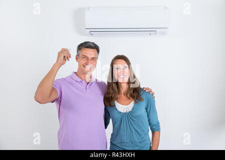 Glückliches Paar Stand Vor der Klimaanlage Stockfoto