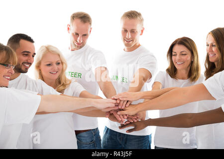 Happy multiethnischen Freiwillige Stapeln Hände Stockfoto