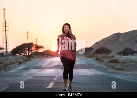 Mädchen, die in den Sonnenuntergang trägt einen rosa Hoody Stockfoto