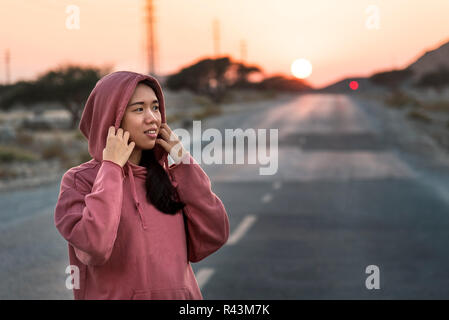 Modische Runner trägt einen rosa Hoody bei Sonnenuntergang Stockfoto