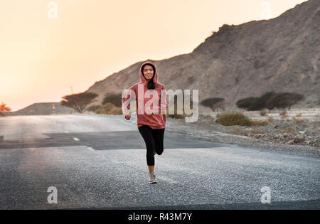 Mädchen, die in den Sonnenuntergang trägt einen rosa Hoody Stockfoto