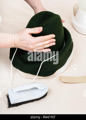 Hutmacher behebt eine Haube auf Dummy fühlte für Gestaltung Stockfoto