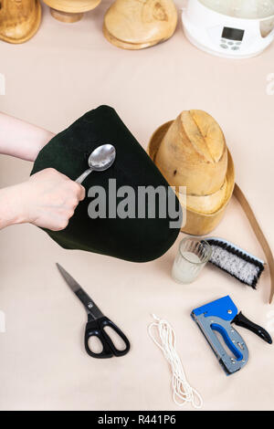 Hutmacher gilt einem Klebstoff, ein Gefühl für die Befestigung an der Motorhaube Stockfoto