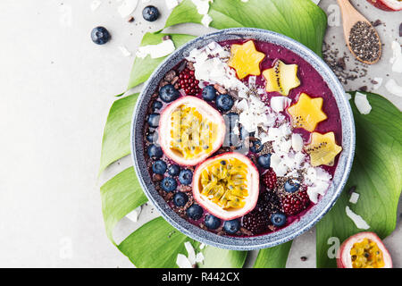 Lecker appetitlichen Smoothie acai Schale von Brombeeren und wilde Beeren, mit Passionsfrucht, Kokosflocken dekoriert, und Kakao Nibs. Serviert Stockfoto