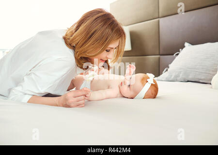 Eine glückliche Großmutter mit Baby Enkel auf dem Bett. Stockfoto