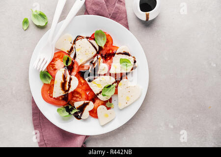 Valentinstag Salat. Klassische italienische Caprese Salat mit Herz gebildet, Mozzarella, Basilikum, Balsamico und Tomaten auf dem Teller serviert. Oben betrachten. Kopieren spa Stockfoto