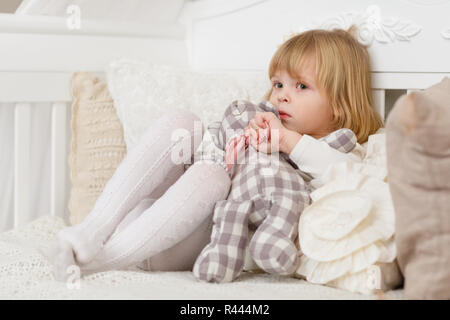 Trauriges Mädchen mit Spielzeug tragen. Stockfoto