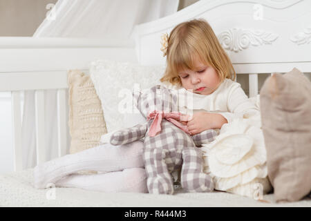 Trauriges Mädchen mit Spielzeug tragen. Stockfoto