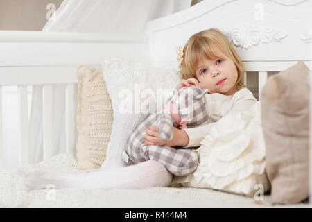 Trauriges Mädchen mit Spielzeug tragen. Stockfoto