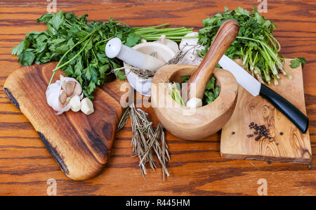 Mörtel und würzigen Kräutern auf hölzernen Tisch Stockfoto