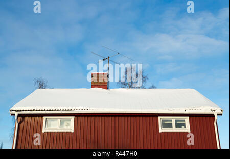 Rotes Haus mit Schnee auf dem Dach Stockfoto