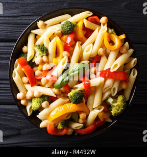 Köstliche Sommer Penne Pasta Rezept mit Kichererbsen, Gemüse, Kräutern und Gewürzen closeup in einem Teller auf dem Tisch. nach oben Ansicht von oben Stockfoto