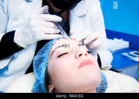 Der Arzt cosmetologist macht den Verjüngenden gesichtseinspritzungen Verfahren zur Straffung und Glättung der Falten auf der Haut einer schönen, sie Stockfoto