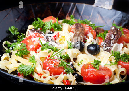 Frische Pasta mit Tomaten und Oliven in einer Pfanne Stockfoto