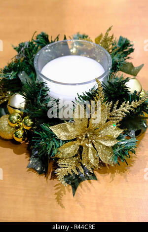 Weihnachten Tischdekoration. Weiße Kerze im Glas durch Gold Flitter und glitter Blumen umgeben. Stockfoto