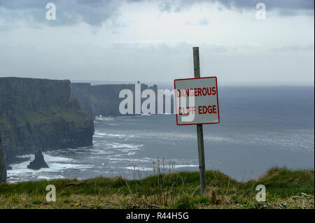 Gefährliche Klippe Zeichen bei bedecktem Wetter Cliffs of Moher in Irland. Warnschild Warnung vor einer vertikalen Tropfen auf die Steilküsten in typischen Irischen Stockfoto