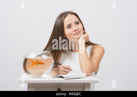 Sie dachte über das Schreiben in ein Notebook-Wunsch, einen Goldfisch zu erfüllen Stockfoto