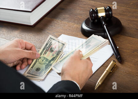Korrupte Richter zählen Geld am Schreibtisch Stockfoto