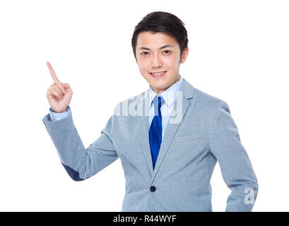 Asian Business Mann lächelnd und mit dem Finger nach oben Stockfoto
