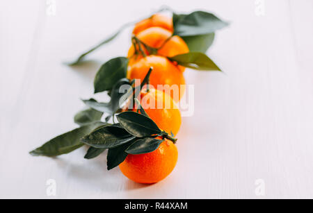 Fünf Mandarinen mit Grün auf weißem Hintergrund. Orange frische Mandarine auf weißem Hintergrund Reif. Stockfoto