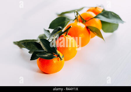 Fünf Mandarinen mit Grün auf weißem Hintergrund. Orange frische Mandarine auf weißem Hintergrund Reif. Stockfoto