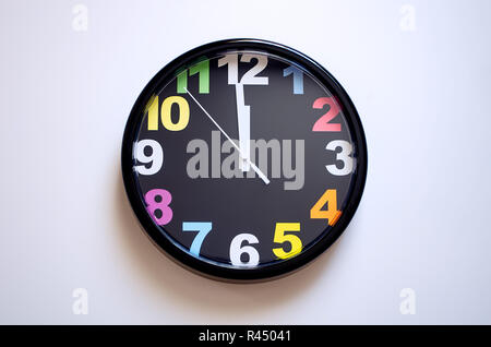 Uhr auf einem weißen Hintergrund. Ein paar Sekunden bis Mitternacht. Mehrfarbige Zahlen auf die Uhr. Stockfoto