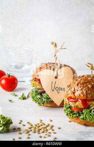 Vegan Linse Burger mit Grünkohl und Tomatensauce auf einem weißen Hintergrund. Auf Basis pflanzlicher Nahrung Konzept. Stockfoto