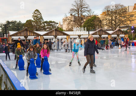 Bournemouth, Dorset, Großbritannien. 25. Nov 2018. Besucher genießen Schlittschuhlaufen auf der Outdoor eislaufen Eisbahn in Bournemouth untere Gärten in Bournemouth im November. im freien Eislaufbahn. Stockfoto