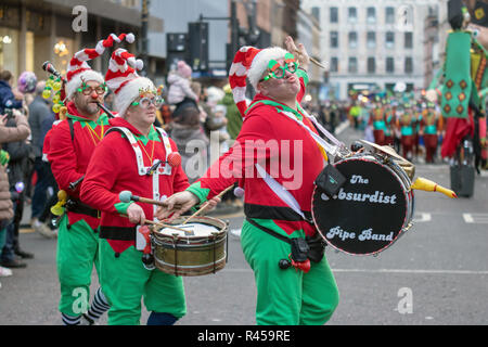 Glasgow, Schottland, Großbritannien. 25. November 2018. Die jährlichen Stil Meile Karneval hat durch das Stadtzentrum von Glasgow aus St. Enoch Square George Square, wo der Weihnachtsmarkt am Nachmittag geöffnet wurde vorgeführt. Tausende von Einheimischen und Touristen beobachtet, Hunderte von festlichen Darsteller in schillernden Kostümen auf die Straßen der größten Stadt Schottlands. Die Prozession wurde von Lord Provost Eva Bolander, zusammen mit 8-jährige Kaleb, Miller, der Beschaffung von Mitteln für Glasgow's Kinder Krankenhaus Liebe. Iain McGuinness/Alamy leben Nachrichten Stockfoto