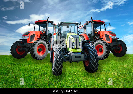 Gruppe der neuen und modernen landwirtschaftlichen generische Traktoren auf der grünen Wiese in sonniger Tag (gemischt) Stockfoto