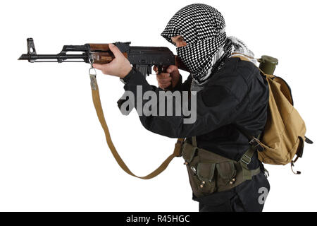 Aufständische in schwarzer Uniform und shemagh Schwarz und Weiß gekleidet mit AK 47 Gewehr isoliert auf weißem Stockfoto