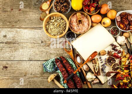 Kochbuch und Gewürz auf einen hölzernen Tisch. Zubereitung von Speisen. Ein altes Buch in der Küche. Rezepte für Lebensmittel. Stockfoto