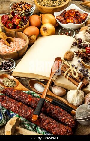 Kochbuch und Gewürz auf einen hölzernen Tisch. Zubereitung von Speisen. Ein altes Buch in der Küche. Rezepte für Lebensmittel. Stockfoto