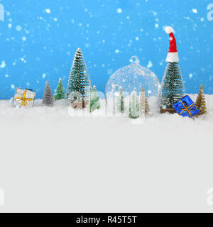 Bild von Weihnachtsbäumen in Glas Kugel über verschneite Holztisch Stockfoto
