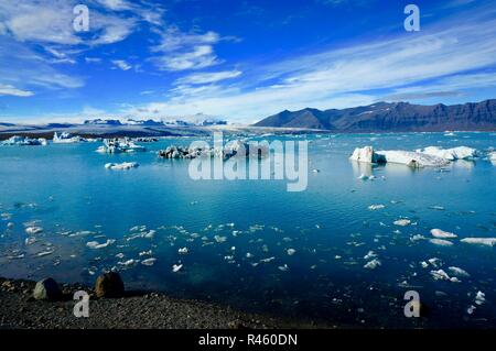 Eisberge auf See und die Berge dahinter. Gletscherlagune Jokulsarlon, Island Stockfoto