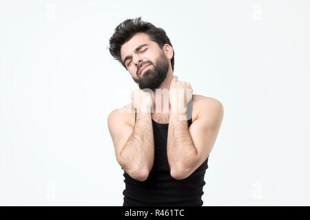 Junger Mann mit hispaniv berad in schwarze Kleidung, Schmerzen im Hals Stockfoto
