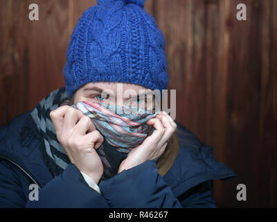 Junge weibliche tragen warme Kleidung für ihr Gesicht mit Schal Stockfoto