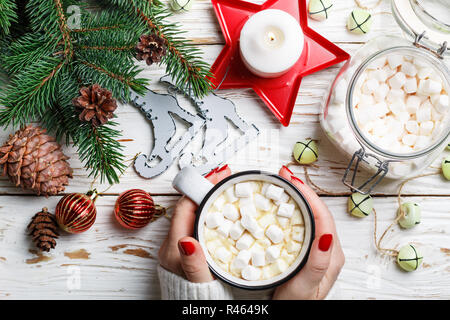 Heiße Schokolade (Kaffee, Kakao) mit Marshmallow in weißen Schale. Weihnachten. Für das neue Jahr. Tannenzweigen, Kerzen, Kegel, Jingle bells und Spielzeug. Urlaub. Wählen Sie Stockfoto