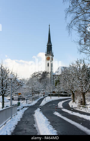 Snowy Blick auf die Kirche St. Jakob von Seestrasse an einem klaren Wintertag in einem kleinen Schweizer Stadt Dorf Cham im Kanton Zug, Schweiz Stockfoto