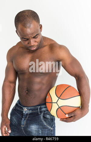 Muskulöse afro-amerikanische Athlet mit Basketball Ball auf weißem Hintergrund Stockfoto